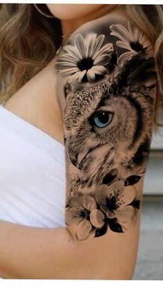 a woman's arm with an owl and flowers on it