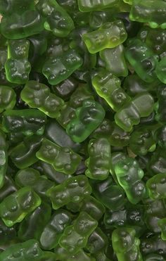 green gummy bears are in the middle of a pile