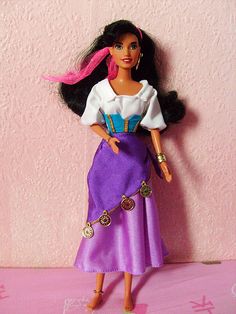 a barbie doll standing on top of a pink surface with her hair in pigtails