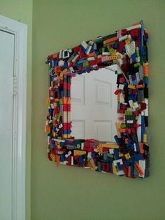 a mirror made out of legos is hanging on the wall next to a door