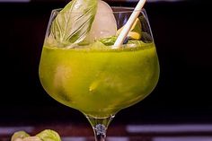 a glass filled with green liquid and garnish