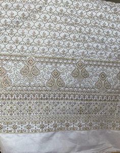 an old white and gold cloth with intricate designs