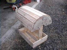 a wooden bench sitting on top of gravel next to a fire hydrant in front of a building