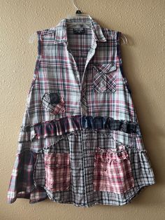 a plaid shirt with ruffles hanging on a wall