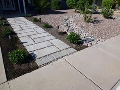 a driveway with rocks and gravel in front of a house