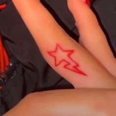 a woman's arm with a red star tattoo on the left side of her body