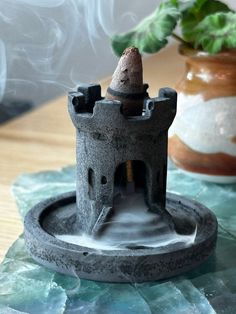 Elevate your space with this handcrafted black concrete medieval castle cone incense holder. Featuring a mesmerizing cascading and pooling smoke effect, this unique incense burner will bring an enchanting atmosphere to any room. This product is designed for use with "backflow" incense cones to create a cascading smoke effect but can also hold standard incense cones. Dimensions: Height: 2 inches Base Diameter: 2.5 inches Material: Concrete Color: Matte black with rustic medieval detailing. Note: Backflow Incense Holder, Cone Incense Holder, Black Concrete, Backflow Incense Burner, Cone Incense, Chateau Medieval, Incense Cone, Backflow Incense, Concrete Color