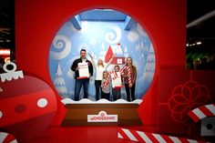 a group of people holding up signs in front of a snow globe with christmas decorations