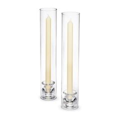 two tall clear candles sitting next to each other