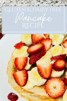 a white plate topped with pancakes covered in sliced bananas and strawberries