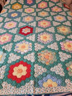 a green quilt with many flowers on it