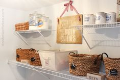 some baskets are sitting on shelves in the closet