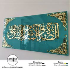 a sign that is on the wall in front of a window with gold lettering and arabic writing