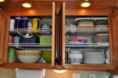 two open cupboards filled with dishes and bowls