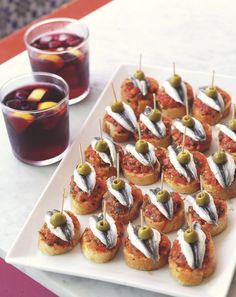 small appetizers with olives are on a white plate