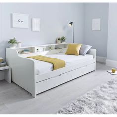 a white bed with yellow pillows in a room