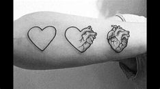 a person with a tattoo on their arm that has three hearts and one heart in the middle