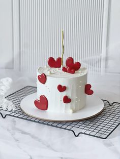 a white cake with red hearts on it