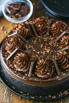 a chocolate cake on a black plate topped with frosting