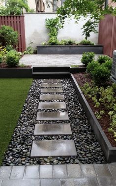 an outdoor garden with stepping stones and grass