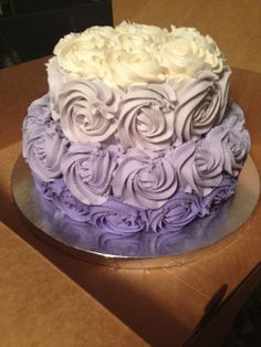 a purple and white cake sitting on top of a cardboard box