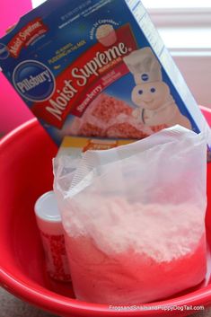 a red bowl filled with cake mix next to a bag of frosting