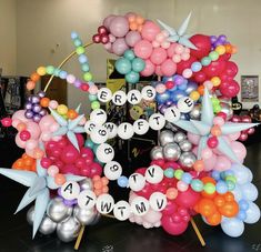 a bunch of balloons that are in the shape of a wreath with words on them