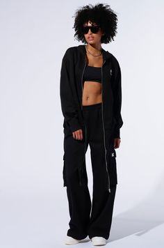 Your day will become infinitely better in The AKIRA Label Take The Long Way Cargo Jogger. These comfy bottoms are crafted from a stretchy cotton knit base and features a high rise design, a shirred elastic waistband, side slant front pockets, dual cargo flap pockets on the thighs with a contrast embroidered “AK” patch, tonal stitching, and a wide leg silhouette. Style with the coordinating AKIRA Label Take The Long Way Oversized Zip Up Hoodie for a finished look. - Shell: 85% Cotton 15% Polyester- Stretch- Imported (all measurements approximate from size small)- 12” Rise- 31” Inseam- Model is 5’9 ½” Product ID: 438025 Comfy Bottoms, Oversized Zip Up Hoodie, All White Party, White Accessories, Easy Trendy Outfits, Wide Calf Boots, How To Stretch Boots, Cargo Joggers, White Party