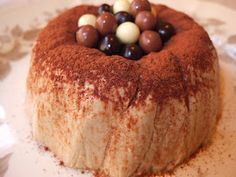 a cake on a plate with chocolates and other candies in the top layer