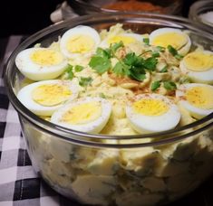 a bowl filled with boiled eggs and garnished with parsley on the side