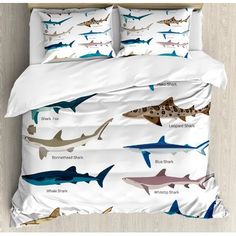 a bed with sharks on it and the names of them in blue, white and brown