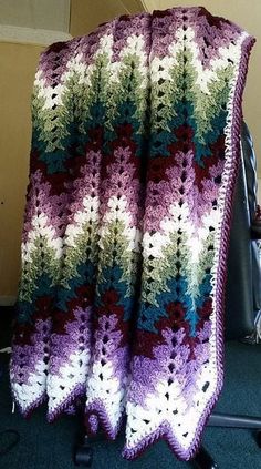 a crocheted blanket sitting on top of a chair