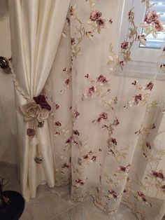 the curtains in the bathroom are decorated with flowers