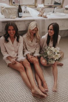 three beautiful women sitting next to each other on the floor