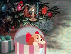 a dog in a pink and white bed next to a christmas tree with presents under it