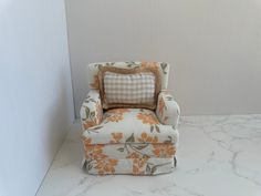 an orange and white chair sitting on top of a marble countertop next to a wall