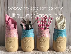 three mason jars filled with paper straws and other decorative items are sitting on a table