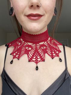 a woman wearing a red crochet choker necklace