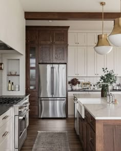 a kitchen with white cabinets and stainless steel appliances, along with wooden flooring that matches the wood paneling