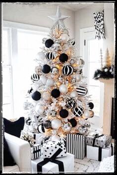 a white christmas tree decorated with black and silver ornaments