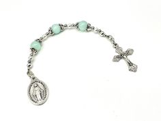 a rosary bracelet with an image of jesus on the cross and green glass beaded beads