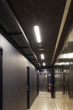 an empty hallway with metal walls and doors