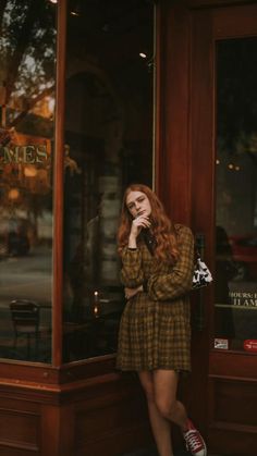 a woman standing in front of a restaurant talking on her cell phone