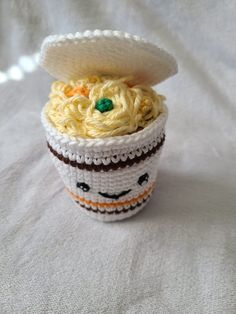 there is a crocheted cup with some food in it