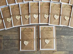 a bunch of brown and white heart shaped cards on top of a wooden table next to each other