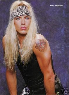 a man with long blonde hair and tattoos on his arm