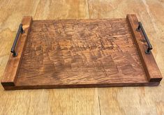 a wooden cutting board sitting on top of a hard wood floor next to a knife holder