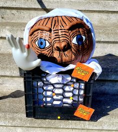 an animal head sitting on top of a basket next to a hand and two orange tags