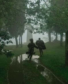 two people walking in the rain with umbrellas