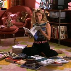 a woman sitting on the floor reading a book